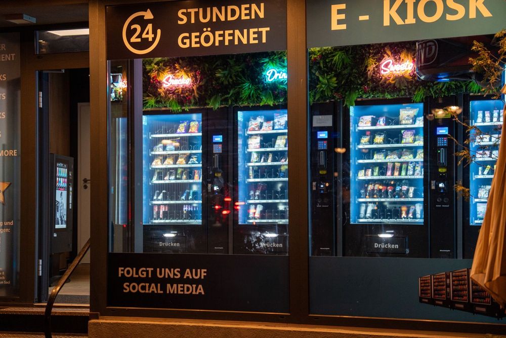 Beleuchteter 24-Stunden-Automaten-Kiosk mit Pulse-Snackautomaten hinter der Schaufensterscheibe