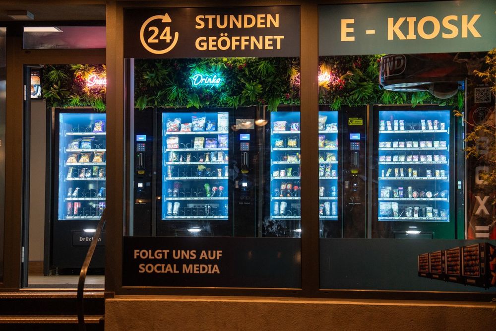 Nachts beleuchteter Automaten-Kiosk mit Schriftzug 24 Stunden geöffnet